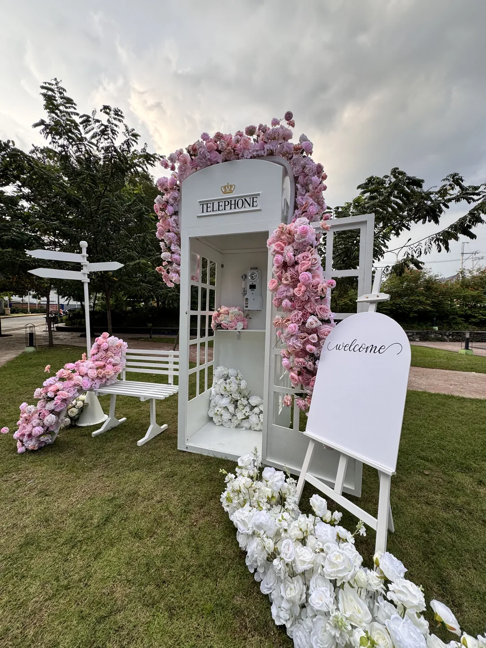 Styled guestbook table and telephone booth at an outdoor event